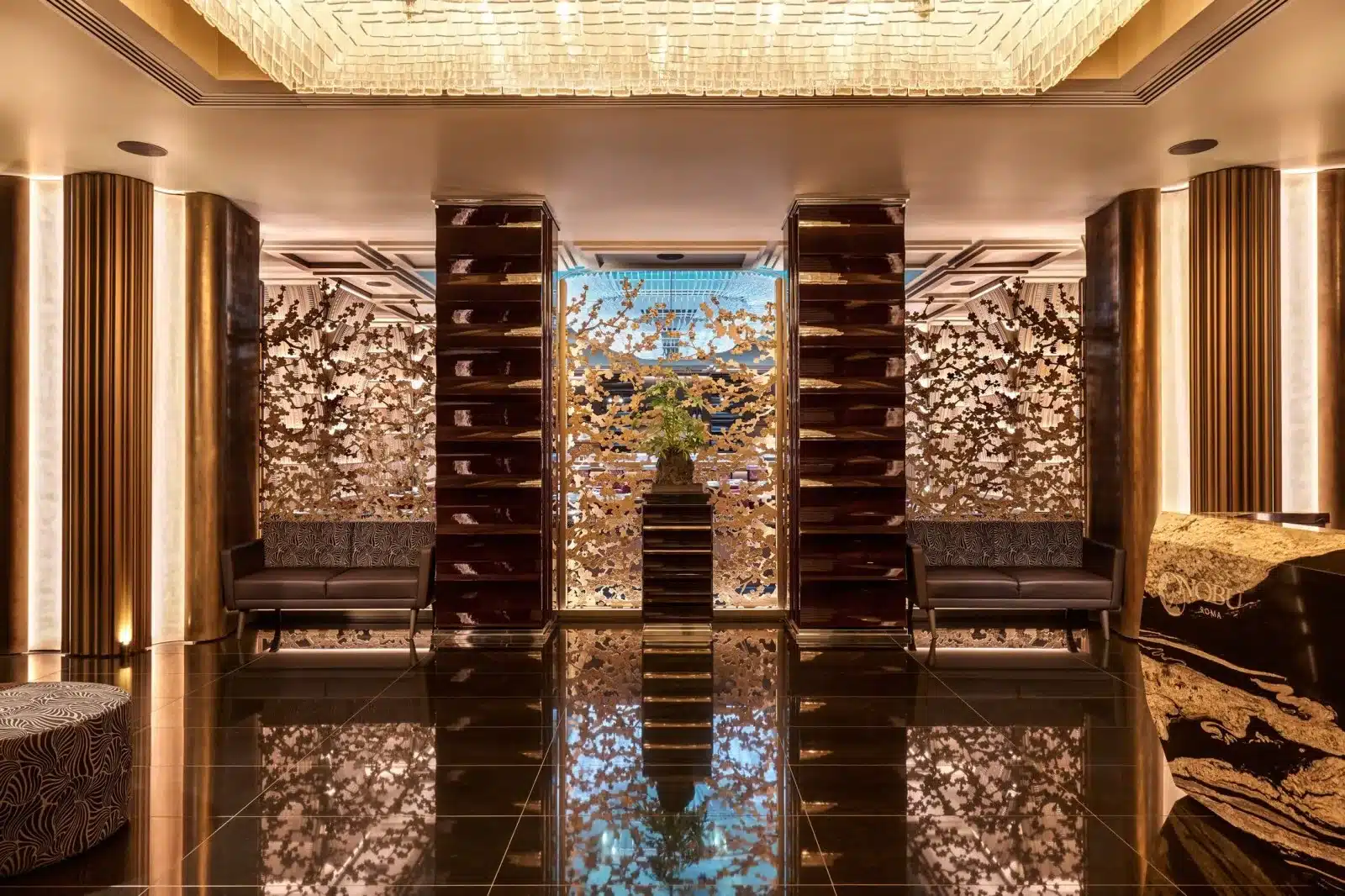 Lobby del Nobu Hotel Roma con legni scuri, pareti materiche e installazione centrale